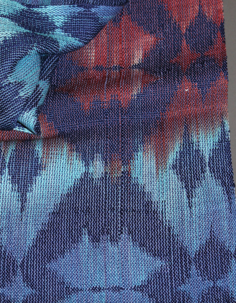 a cloth woven in blues and reds with a lot of mixing of colors and undulations